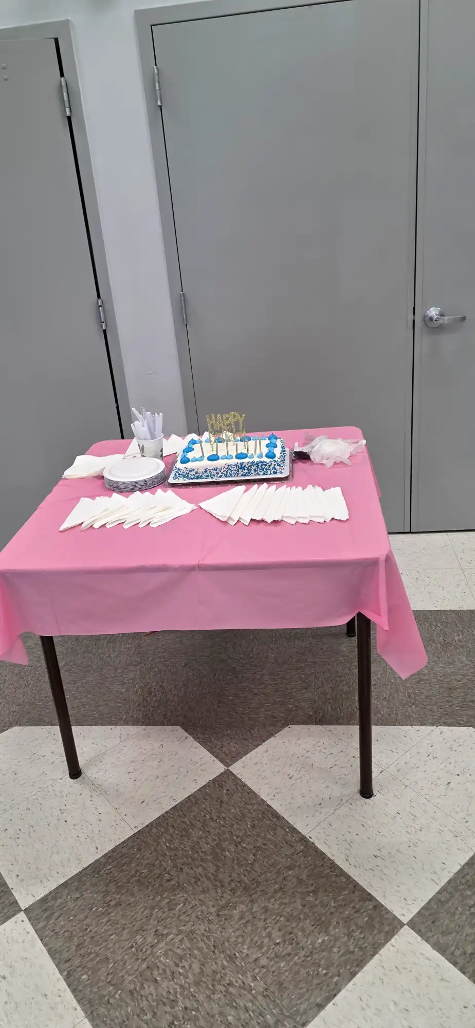 Pink table setup with celebration cake and party supplies